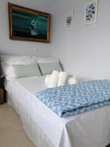 a bed in a bedroom with a picture on the wall at Bluefullstop-Μπλε Τελεία in Artemida