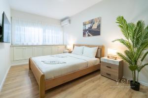 a bedroom with a bed and a potted plant at Duplex in Piraeus' Best Street 2Bath w-FreeParking in Piraeus