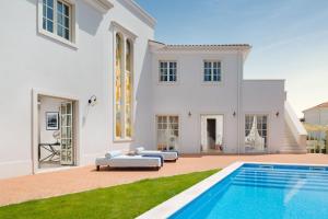 瓦布里加Villa Aurora by Villas Borghetto的一座白色的房子,前面设有一个游泳池