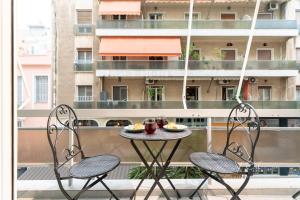 a table and two chairs on a balcony with a table and chairs at Duplex in Piraeus' Best Street 2Bath w-FreeParking in Piraeus