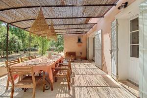 een eetkamer met een tafel en stoelen op een terras bij La maison Calavoun in Maubec