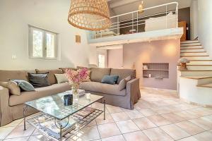 een woonkamer met een bank en een glazen tafel bij La maison Calavoun in Maubec +31 foto's