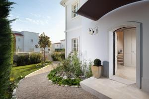 瓦布里加Villa Aurora by Villas Borghetto的白色的房子,带鲜花庭院