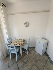 a table and chairs in a room with a clock on the wall at Fantasy House 2.0 in Forio d'Ischia +6 photos