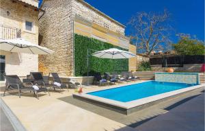 Una piscina con sillas y sombrillas al lado de un edificio. en Villa Patrick, en Pazin