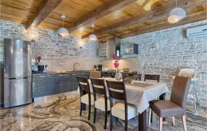 Una cocina con una mesa con sillas y un refrigerador. en Villa Patrick, en Pazin