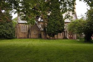 an old stone house with a large grass yard at Magpies Restaurant with Rooms in Horncastle