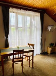 un tavolo e due sedie in una stanza con finestra di Hvězdonice Hostinec U Kuželků a Hvězdonice Altre 37 foto