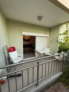 a balcony with white chairs and a table on it at two bedroom apartment with parking in Petrovac na Moru