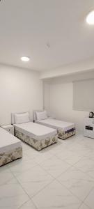 two beds in a room with white walls at دانة - Dana in Medina