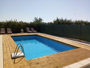 a swimming pool with a wooden deck and a swimming poolvisor at Ulivo Apartment in Ragusa +42 photos