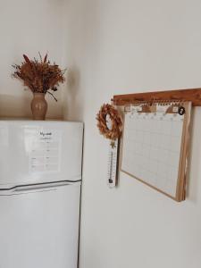 a calendar on the wall next to a refrigerator at Le gîte de Marceau in Labergement-lès-Auxonne