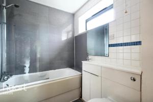 a bathroom with a tub and a sink and a mirror at North Point, Leeds City Centre in Central Station