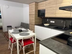 a small kitchen with a white table and chairs at Dimora Casere 3 - zona centro in Piancavallo