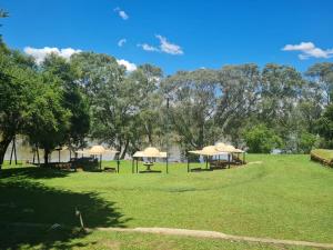 two picnic tables with umbrellas in a park at The Lion Lodge Vaal in Lindequesdrif