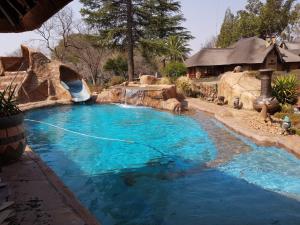 a pool in a backyard with a water slide at The Lion Lodge Vaal in Lindequesdrif