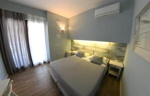 a bedroom with a bed and a desk and a window at Monti' B&B Agropoli Lungomare in Agropoli