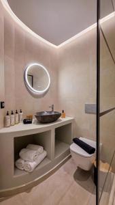 a bathroom with a sink and a toilet and a mirror at AetherOia Suites in Oia +60 photos