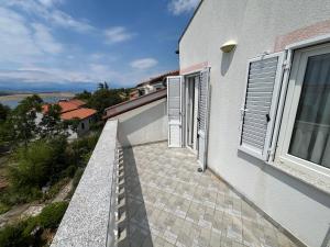 un balcon d'un immeuble blanc avec une fenêtre dans l'établissement Apartmani Rosa, à Jadranovo
