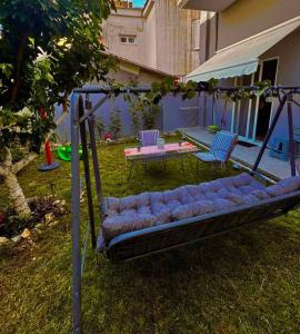 a swing in a yard with a table and chairs at PREVEZA DOWNTOWN garden in Preveza
