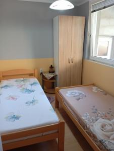 a bedroom with two beds and a cabinet at Milica Apartmani in Vrdnik