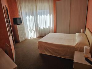 Posteľ alebo postele v izbe v ubytovaní Hotel Corona