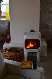 a stove with a fire in it next to a couch at Stylish seaside barn in Borrby