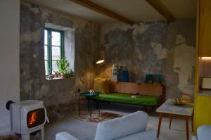 a living room with a green couch and a fireplace at Modern seaside barn in Borrby