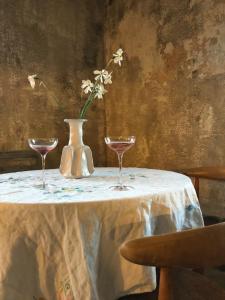 a table with two glasses and a vase with flowers at Stylish seaside barn in Borrby