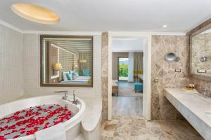 La salle de bains est pourvue d'une baignoire avec une couverture rouge. dans l'établissement Wome Deluxe Hotel - Halal All Inclusive, à Avsallar