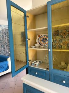 a blue cabinet with glass doors in a kitchen at Casa Pélagos a 50mt dal mare in Nicotera Marina