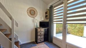 a room with a television and a dresser with a window at Vaux sur Mer - côté PONTAILLAC - VILLA MITOYENNE - PISCINE COLLECTIVE in Vaux-sur-Mer