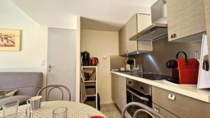 a small apartment kitchen with a table and a couch at Vaux sur Mer - côté PONTAILLAC - VILLA MITOYENNE - PISCINE COLLECTIVE in Vaux-sur-Mer