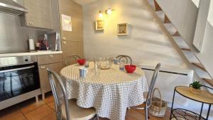 a kitchen with a table with chairs and a table and a kitchen at Vaux sur Mer - côté PONTAILLAC - VILLA MITOYENNE - PISCINE COLLECTIVE in Vaux-sur-Mer +24 photos