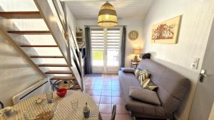 a living room with a couch and a table at Vaux sur Mer - côté PONTAILLAC - VILLA MITOYENNE - PISCINE COLLECTIVE in Vaux-sur-Mer