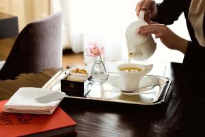 a person pouring a cup of coffee on a tray at The St. Regis Chengdu in Chengdu