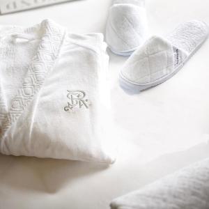 a pair of white shoes and towels on a bed at The St. Regis Chengdu in Chengdu