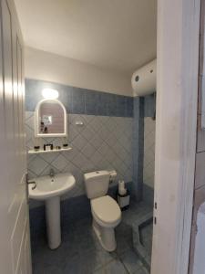 a bathroom with a white toilet and a sink at Socrates House Kythnos in Kithnos