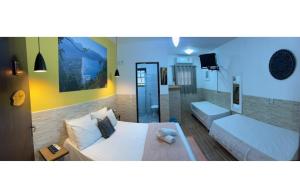 a bedroom with two beds and a tv in it at pousada marèatoa 9 in São Sebastião