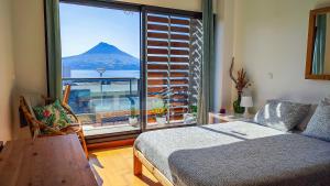 1 dormitorio con cama y vistas a la montaña en AL Vista Alegre, en Horta
