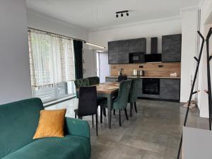 ein Wohnzimmer mit einer grünen Couch und einem Tisch in der Unterkunft Vigorhaus in Połęcko