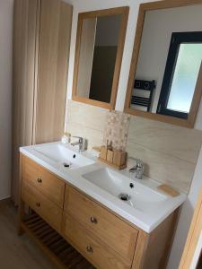une salle de bain avec un lavabo blanc et un miroir dans l'établissement Villa Détente, à Hourtin 27 autres photos