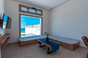 a living room with a couch and a large window at Alimbali Villas in Karpathos
