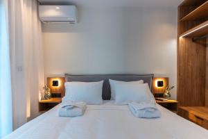 a bedroom with a large white bed with two towels at Alimbali Villas in Karpathos +51 photos