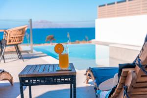 a table with a drink on it next to a pool at Alimbali Villas in Karpathos