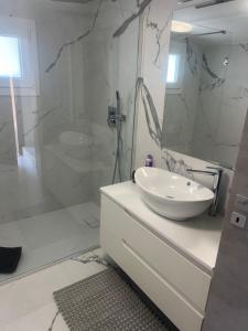 a white bathroom with a sink and a shower at Villa Lollo in Camporosso +38 photos