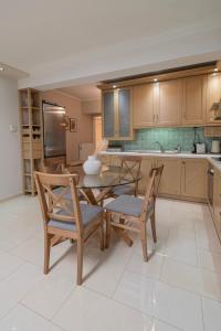a kitchen with a glass table and chairs and a counter at Agnes by RentalsPro - Nea Moudania Halkidiki in Nea Moudania +32 photos