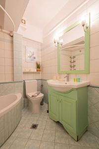 a bathroom with a sink and a toilet and a mirror at Agnes by RentalsPro - Nea Moudania Halkidiki in Nea Moudania