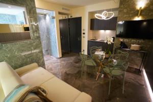 Una sala de estar con un sofá y una mesa con sillas. en Ale Suite Sea Side View - Hotel Arizona, en Riccione