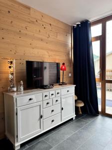 a white dresser with a television on top of it at Appartement à La Bresse - cadre naturel et calme in La Bresse